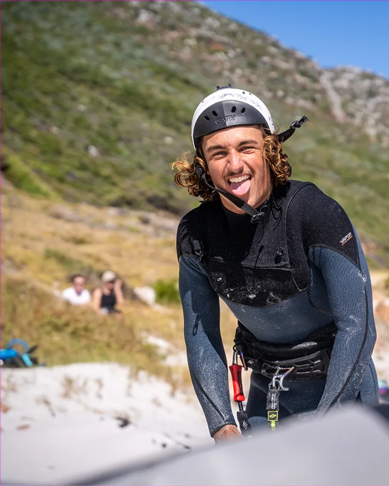 A rider grinning under his helmet on the beach